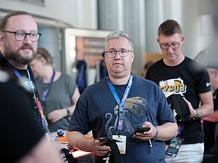 People wearing conference badges and lanyards at a tech event or convention