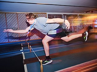 Person in athletic wear performing a running motion on a treadmill at an indoor fitness facility with motion blur effect