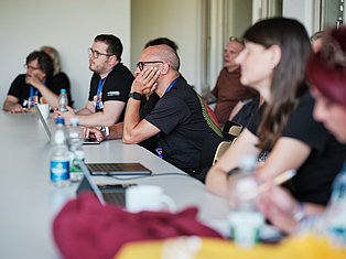 Group of professionals seated at a conference table during a business meeting or panel discussion
