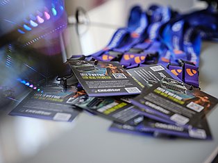 Gaming peripherals display with blue and purple illuminated mouse pads, gaming mouse, and product packaging with QR codes