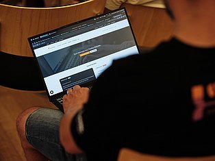 Person holding laptop displaying website builder interface with 'Build Blazingly Fast, Flexible Websites' text