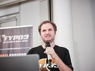 Man speaking at podium with microphone at TYPO3 conference event